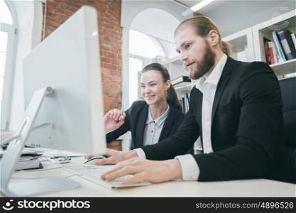 Business people working together. Two business people working together in the office looking at one monitor