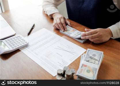 Business people working with dollar bill and coin stack in office room.