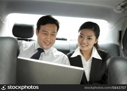 business people working with laptop in the car