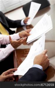 business peoples hands on a desk holding documents