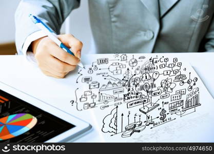 Business person at work. Image of businesswoman sitting at table and drawing sketch