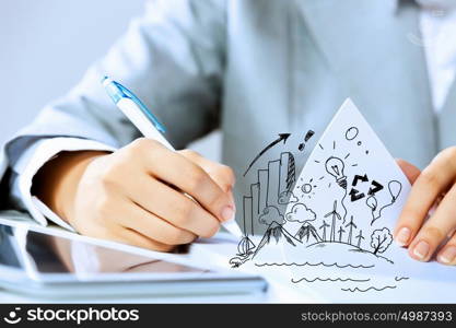 Business person at work. Image of businesswoman sitting at table and drawing sketch