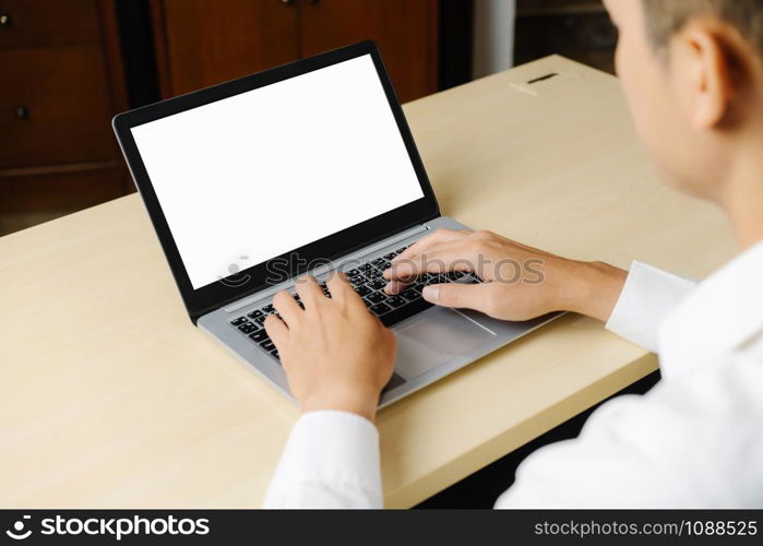 Business person or office worker using laptop computer while sitting at desk.