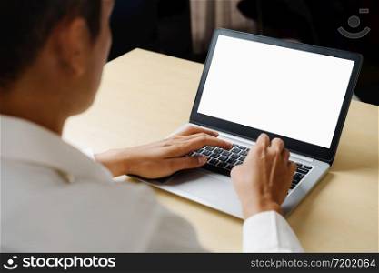 Business person or office worker using laptop computer while sitting at desk.