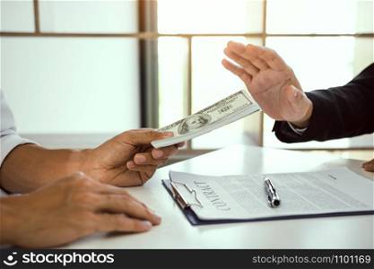 Business person refusing bribe given money by partner with anti bribery corruption concept.