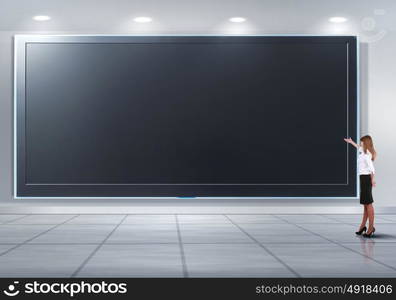 Business person standing near a blank billboard