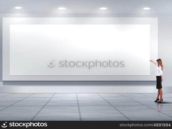 Business person standing near a blank billboard