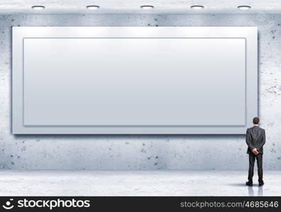 Business person standing near a blank billboard. Business person standing near a white blank billboard