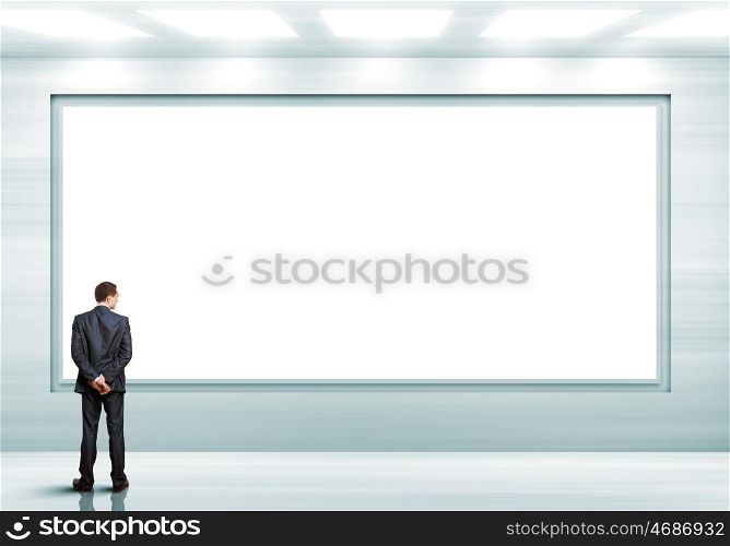 Business person standing near a blank billboard. Business person standing near a white blank billboard