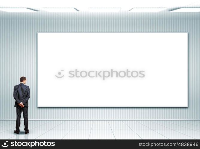 Business person standing near a blank billboard. Business person standing near a white blank billboard