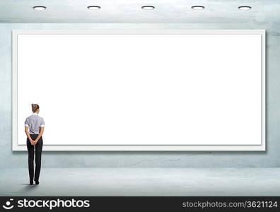 Business person standing near a white blank billboard