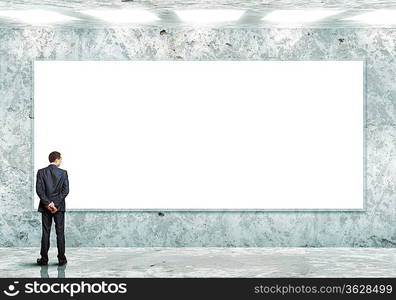 Business person standing near a white blank billboard