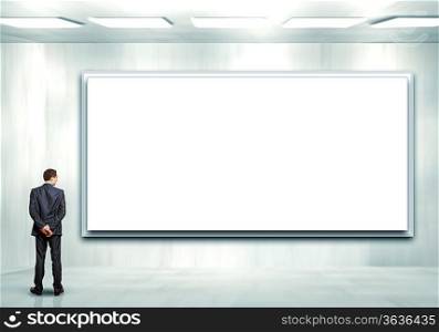 Business person standing near a white blank billboard