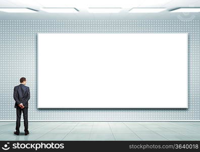 Business person standing near a white blank billboard