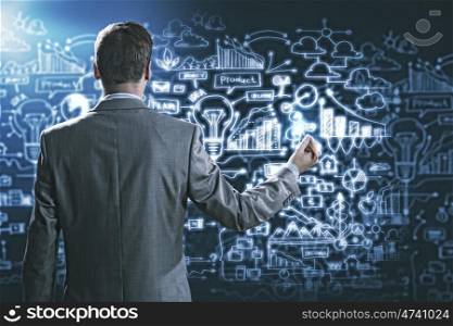 Business plan. Businessman standing with back against media screen
