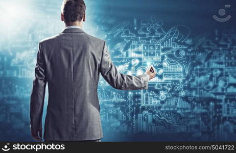 Business plan. Businessman standing with back against media screen