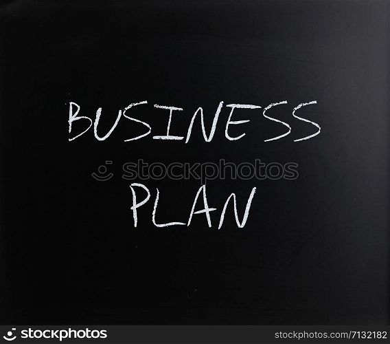 ""Business plan" handwritten with white chalk on a blackboard."
