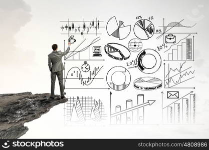 Business planning. Back view of businessman drawing plan sketches on wall