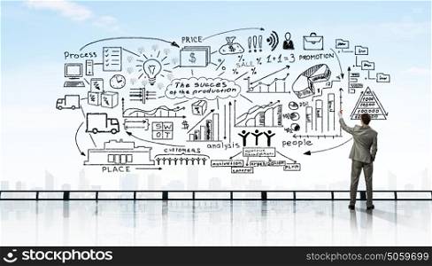 Business planning. Back view of businessman drawing plan sketches on wall