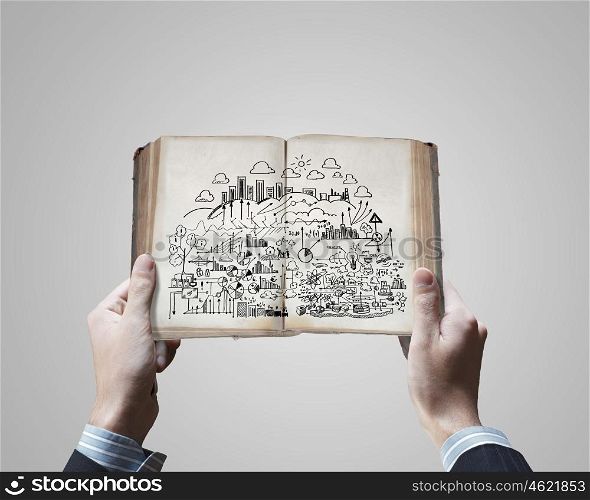 Business planning. Close up of businessman hands holding opened book with sketches