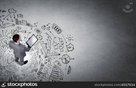 Business planning. Top view of businessman looking at business sketches on floor