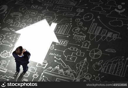 Business planning. Top view of businessman looking at business sketches on floor