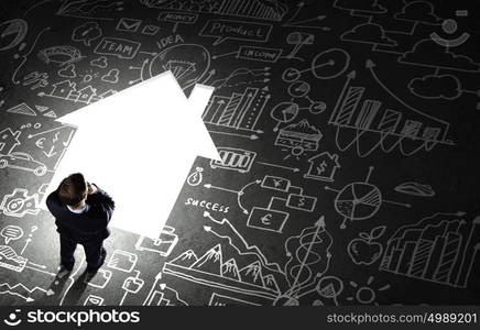 Business planning. Top view of businessman looking at business sketches on floor