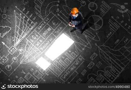 Business planning. Top view of businessman looking at business sketches on floor