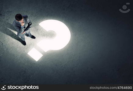 Business planning. Top view of businessman looking at question mark on floor