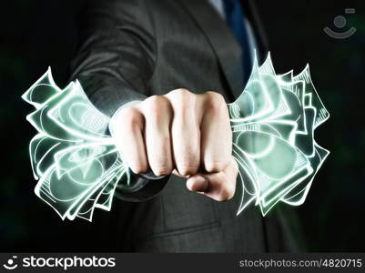 Business power. Close up of businessman grasping dollar banknotes in fist