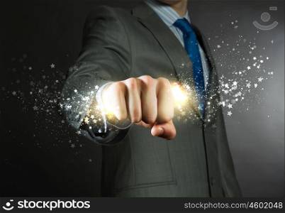 Business power. Close up of businessman grasping star dust in fist