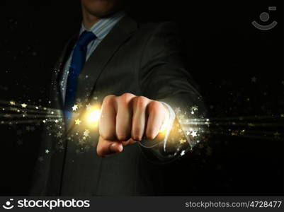 Business power. Close up of businessman grasping star dust in fist