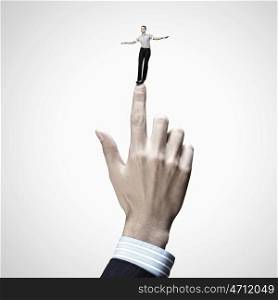 Business power. Young businesswoman balancing on finger of businessman