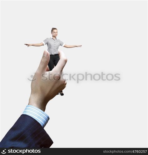 Business power. Young businesswoman in miniature in hand of businessman