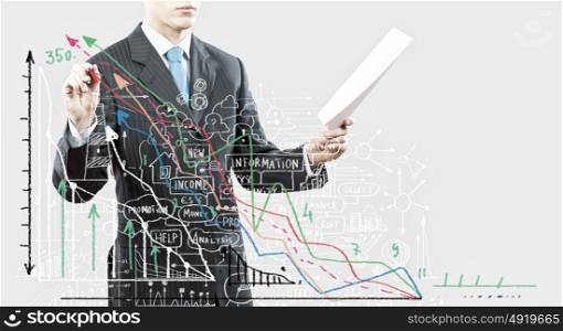 Business presentation. Close up of businessman with documents in hand drawing business sketches