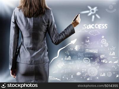 Business presentation. Rear view of businesswoman drawing business sketches