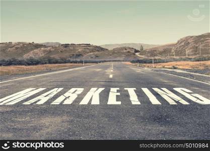 Business process management. Asphalt road with word marketing as business motivation