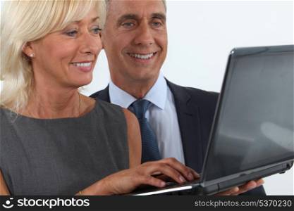 Business professionals looking at a laptop