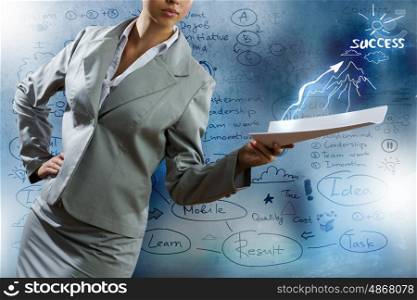 Business project. Businesswoman holding papers in hand and business sketches at background