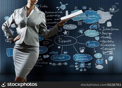 Business project. Businesswoman holding papers in hand and business sketches at background