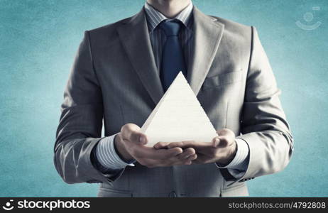 Business pyramid. Close up of businessman holding pyramid in hands