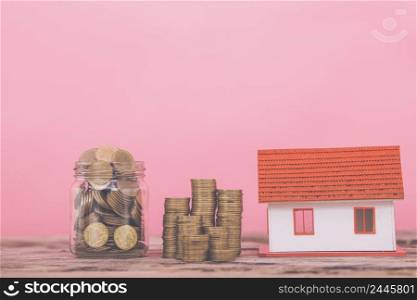 Business Real Estate Concept, House model with a key and dollar bills put on paper graph on wooden background.
