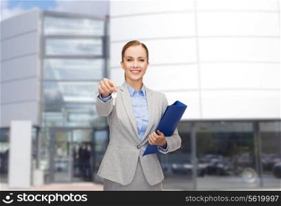 business, real estate, property and office concept - smiling businesswoman with folder and keys