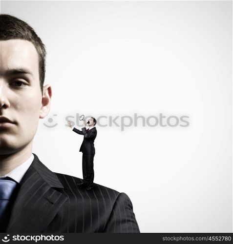 Business relations. Miniature of businessman screaming in megaphone standing on boss shoulder