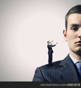 Business relations. Miniature of businessman screaming in megaphone standing on boss shoulder