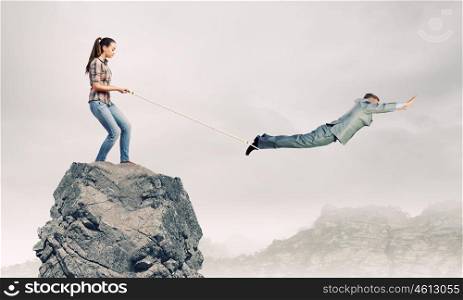 Business relations. Woman holding on rope businessman trying to escape