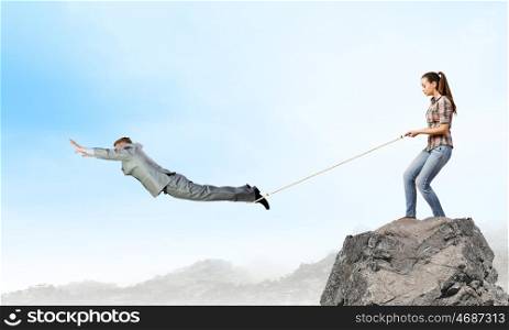 Business relations. Woman holding on rope businessman trying to escape