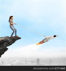 Business relations. Woman holding on rope businesswoman trying to escape