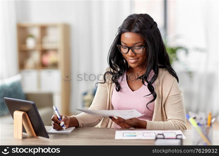 business, remote job and technology concept - african american female ui designer with tablet pc computer working on user interface design at home office. african woman working on ui design at home office