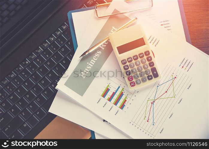 Business report chart preparing graphs calculator on laptop / Summary report in Statistics circle Pie chart on paper business document financial chart and graph with pen on top view